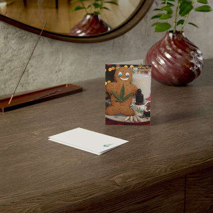 Gingerbread man stoner card standing and one laying facedown on a nicely decorated table.