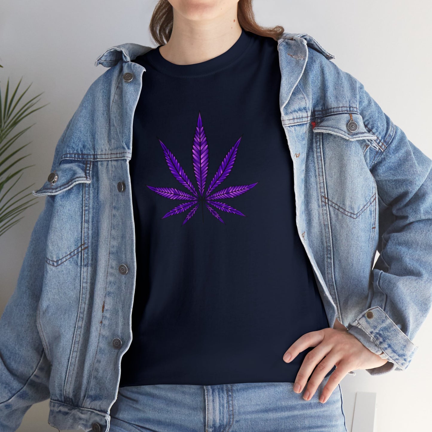 Sentence with Product Name: A person wearing a vibrant color Ganja Leaf Tee, layered with a light blue denim jacket, standing against an indoor background.