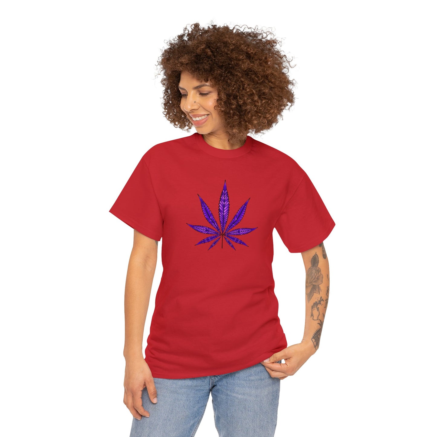 A woman wearing a Purple Cannabis Leaf Tee with a vibrant color stands against a white background, with her left hand resting on her hip.