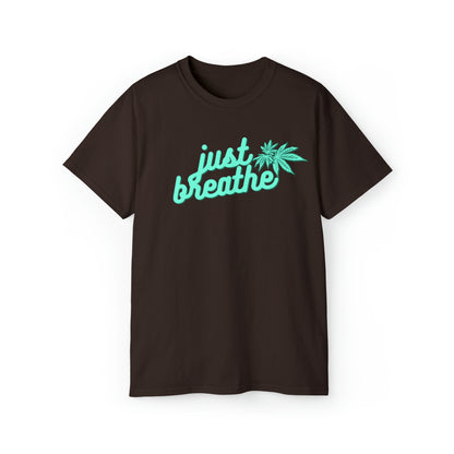 Introducing the Just Breathe Cannabis Tee: a black t-shirt featuring the words "just breathe" in light blue, accompanied by a serene cannabis leaf design on the right side. Perfect for promoting relaxation and style in one simple message.