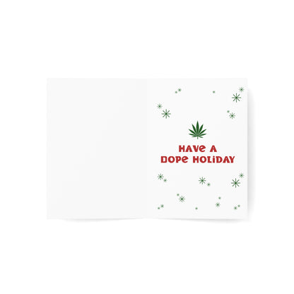 Open Have a Dope Holiday Merry Christmas Happy New Year Greeting Card with the text "have a dope holiday" and a cannabis leaf graphic surrounded by green snowflakes, on sustainable paper, against a white background.