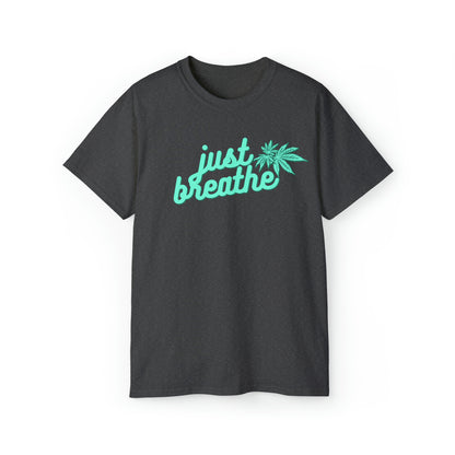 Dark gray T-shirt with turquoise "just breathe" text and a green cannabis leaf graphic, embodying relaxation and style. This Just Breathe Cannabis Tee is perfect for those looking to unwind in comfort.