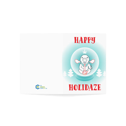 Holiday card featuring a cartoon Buddha meditating inside a snow globe, surrounded by snowflakes, with "Happy Holidaze Zen Lion Smoking Bong Merry Christmas" text above, printed on sustainable paper.