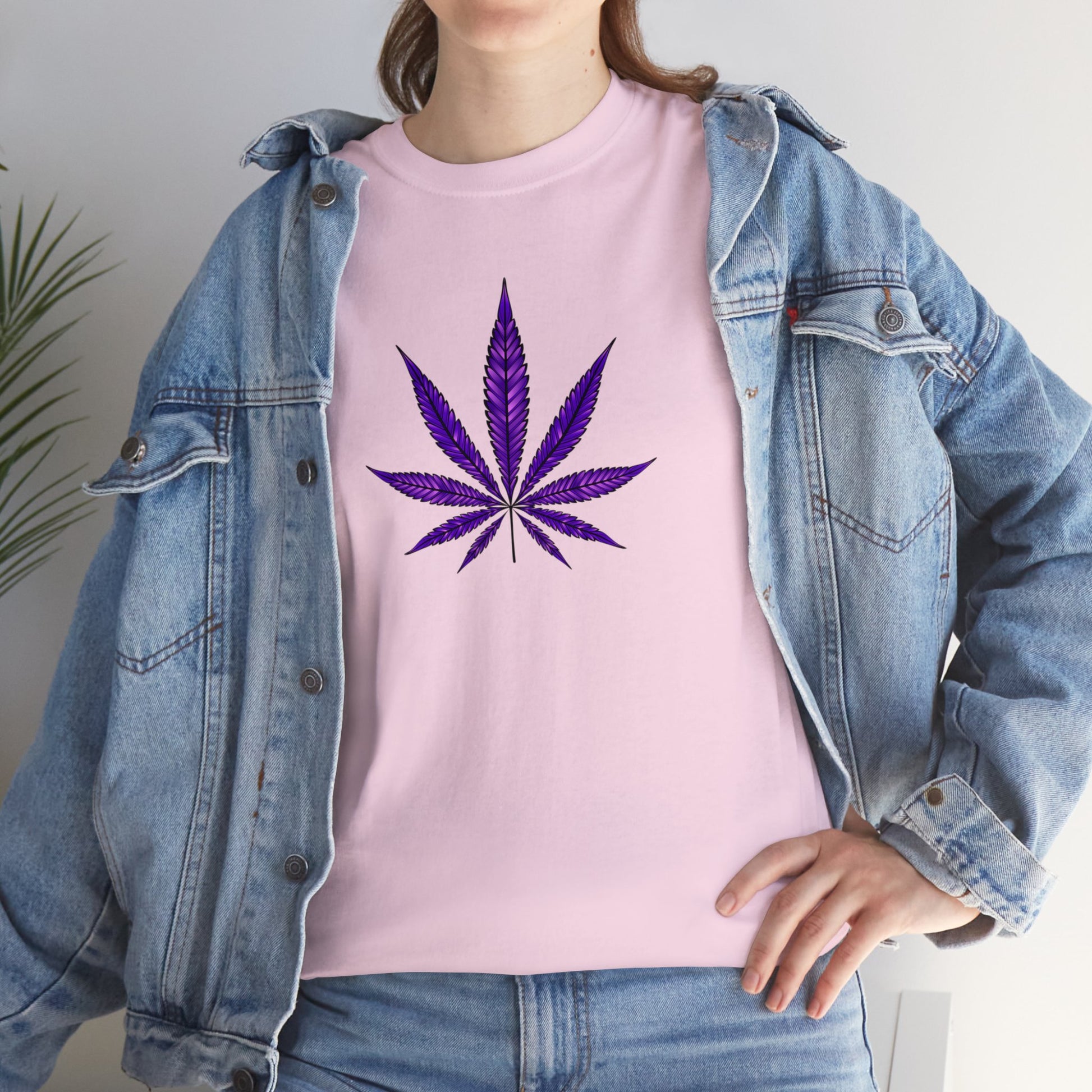 A person wearing a vibrant Purple Cannabis Leaf Tee, layered under a blue denim jacket, symbolizing marijuana culture.