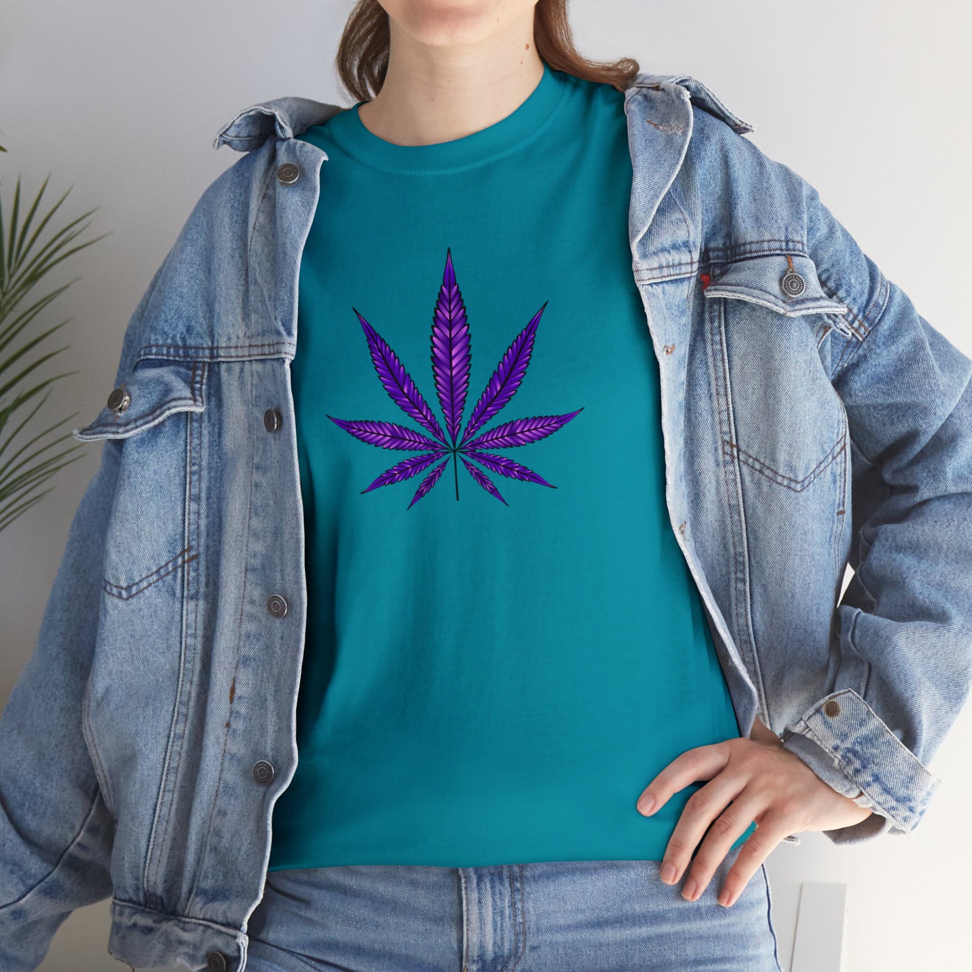 A person wearing a vibrant color, Purple Cannabis Leaf Tee, partially covered by an unbuttoned blue denim jacket, reflecting marijuana culture.