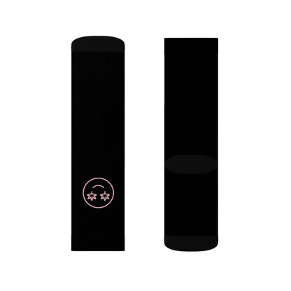 The High Stepper Weed Socks set includes two black crew socks: one with a small pink-outlined smiley face with star-shaped eyes near the toe, and the other sock is plain.