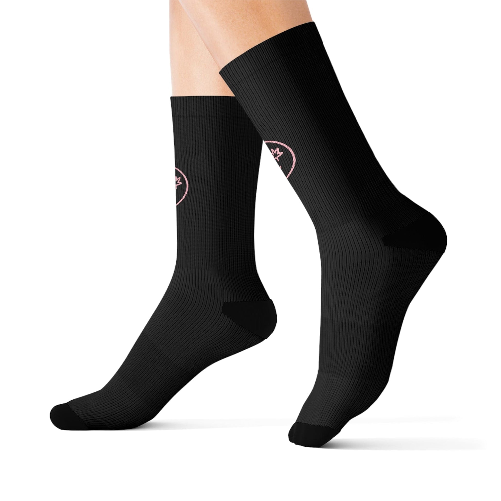 A pair of legs wears black High Stepper Weed Socks, crew length, with a small circular pink emblem near the top.