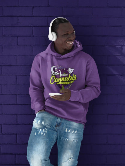 Smiling Black man Leaning against dark purple brick wall wearing a Team Indica light purple cannabis hoodie