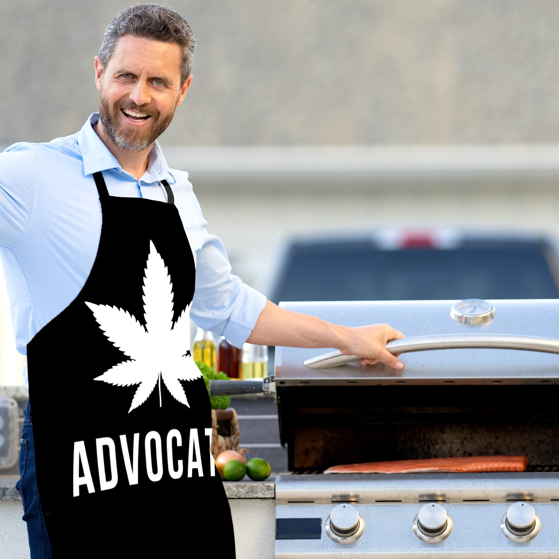 A man wears the Cannabis Advocate Pot Leaf | Apron in black and white