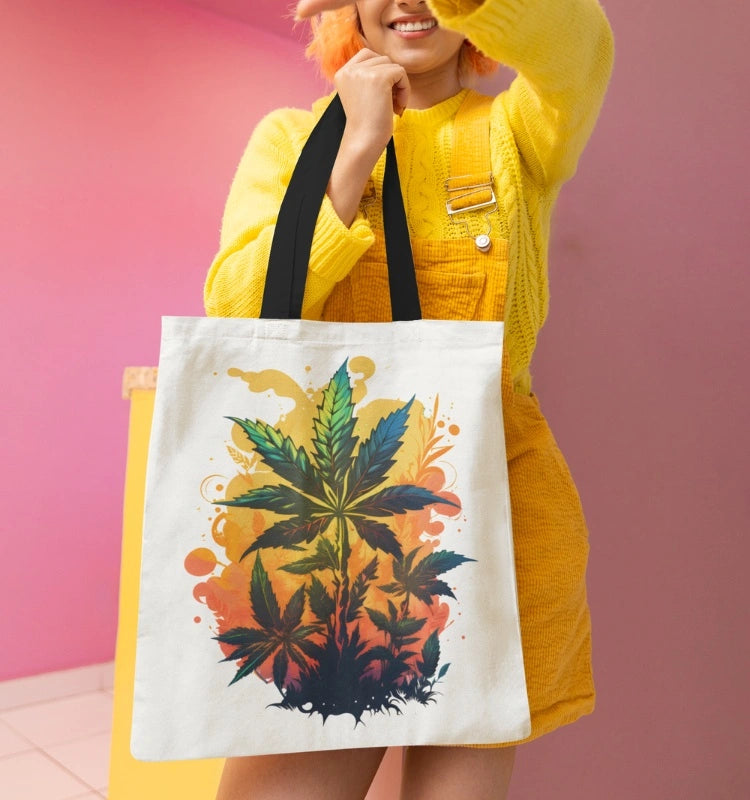 A person wearing a yellow dress holds the Warm Cannabis Paradise Weed Tote Bag, which features a stylish and colorful illustration of cannabis leaves.