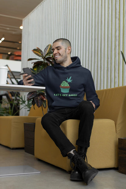 Man sitting on a yellow chair playing on his phone wearing a Let's Get Baked Cannabis Hoodie