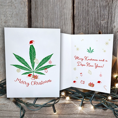 Christmas card with a cannabis leaf and "merry christmas" on the front, printed on FSC certified paper, and "mary kushmas and a dope new year!" inside, surrounded by festive Mary Kushmas + Dope New Year Marijuana Tree Christmas Greeting Cards (1, 10, 30, and 50pcs)