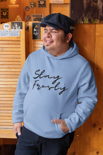 Hispanic man leaning agains a wall wearing a Stay Frosty light blue cannabis hoodie