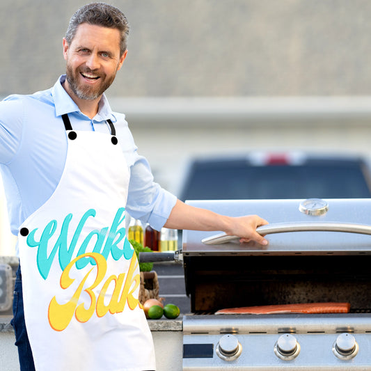 An older man wearing the Wake and Bake Chef's Apron while barbecuing salmon on the grill