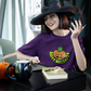 Witch sitting at desk wearing a purple Happy Halloween Pumpkin Stoner Weed Shirt
