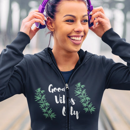 A closeup of a young woman wearing a good vibes only weed zip up hoodie