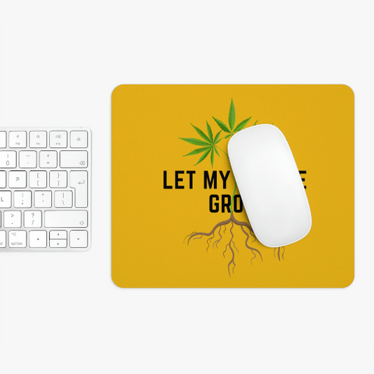 A white keyboard next to a yellow Let My People Grow Yellow Mousepad with a cannabis leaf design and the text "let my people grow" under a computer mouse.