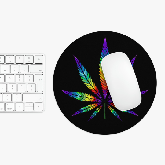 A white computer mouse on a Rainbow Marijuana Leaf mouse pad with colorful feather design, adjacent to a white keyboard on a white surface.