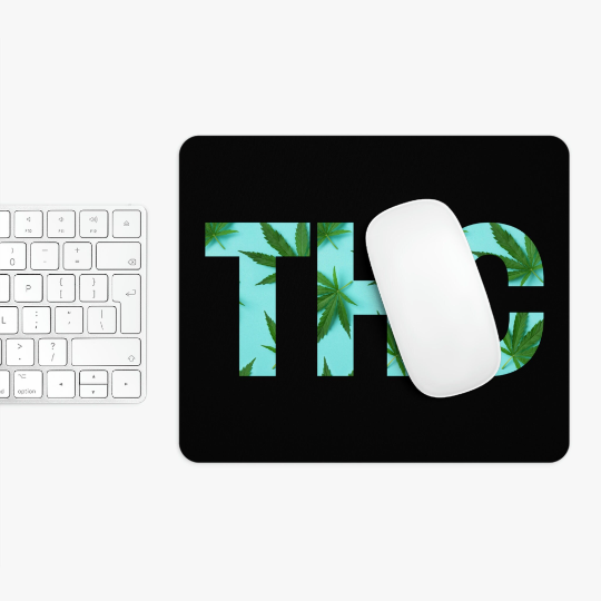 A white computer keyboard with a white mouse on a THC Marijuana Black Mouse Pad featuring a "THC" logo with a marijuana leaf design.