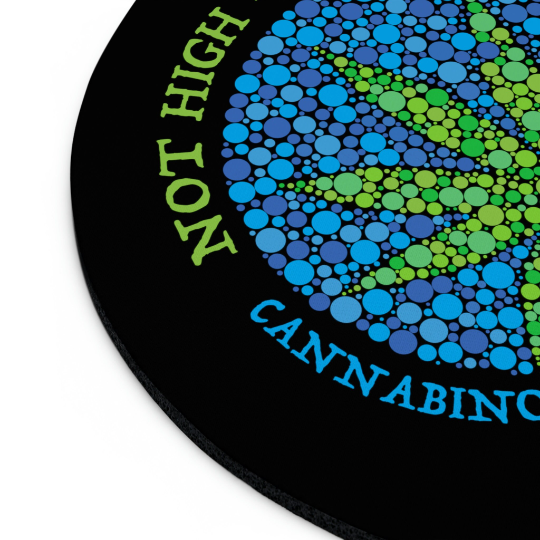 Circular non-slip Not High, Just Well Black Mouse Pad featuring a colorful dot pattern that forms a spiral and the text "not high on cannabinoids" around the edge.
