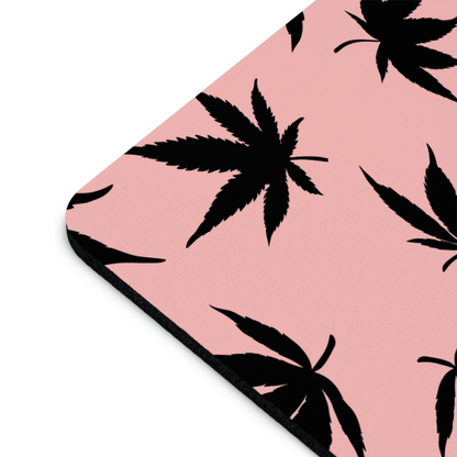 A corner of a high-quality Marijuana Leaves Pink Mouse Pad featuring a black cannabis leaf pattern.