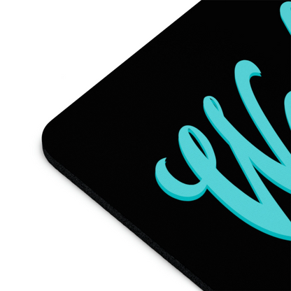 Close-up of a black non-slip Wake and Bake Cannabis mouse pad with a teal cursive script in the corner, displayed on a white background.