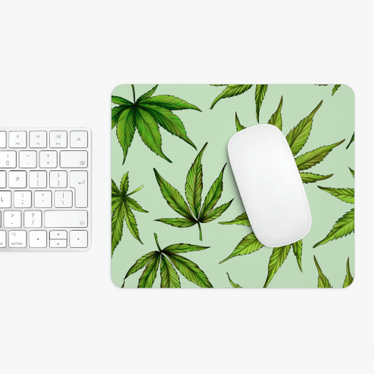 White computer mouse on a Green Marijuana Leaves Mouse Pad with a non-slip base, next to a white keyboard on a white surface.