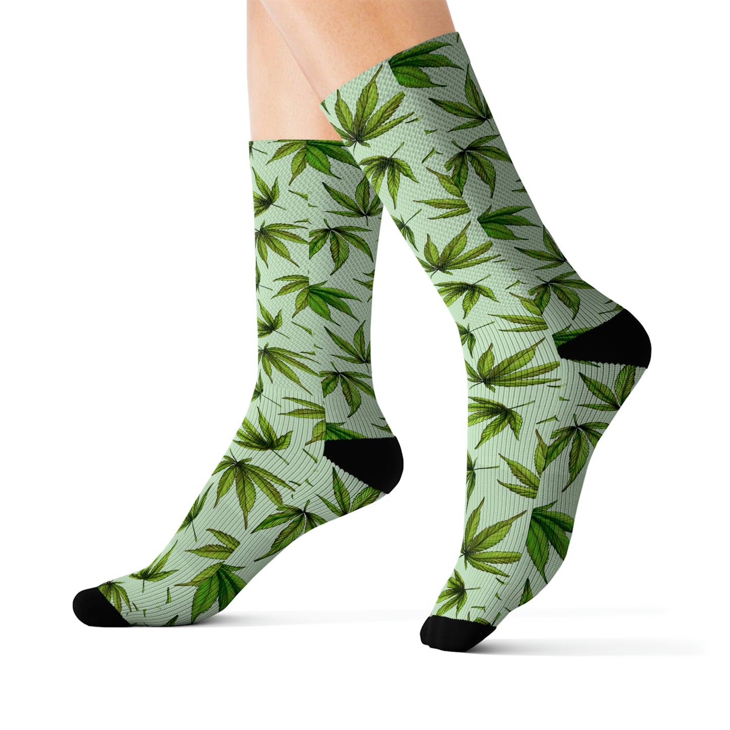 a close up of a pair of green and black weed socks with green cannabis leaves all over a green background