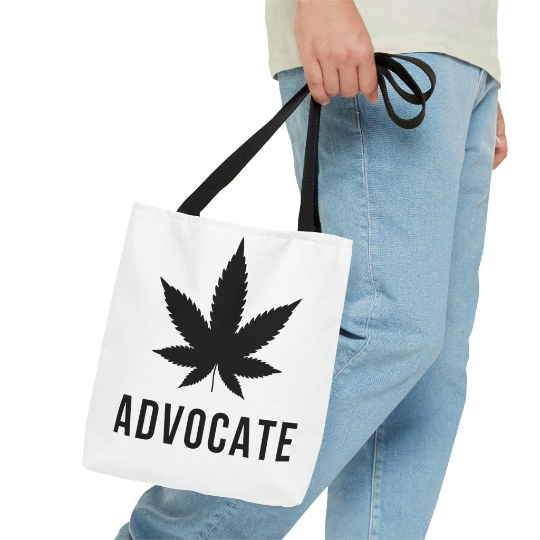 A black and white Cannabis Advocate Pot Leaf | Beach Grocery Tote Bag with bold black cannabis leaf on front center
