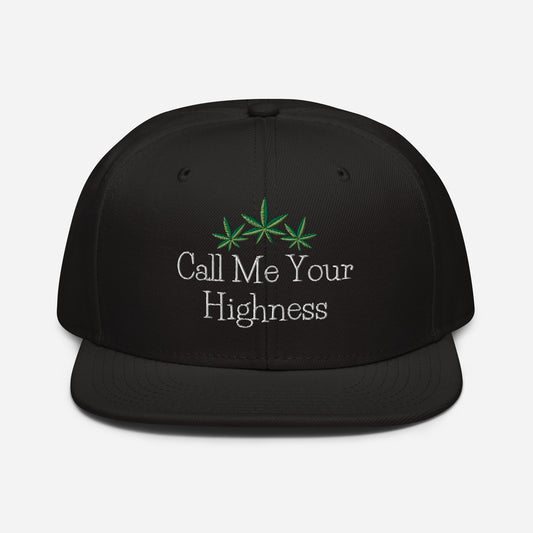 Black structured Call Me Your Highness Snapback Hat with the phrase "call me your highness" embroidered in white, featuring green cannabis leaves above the text.