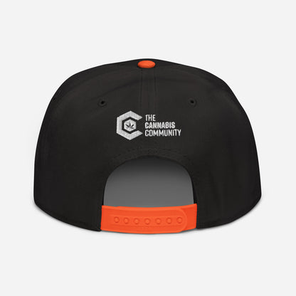 Golden Goat Cannabis snapback hat with an orange adjustable strap and a high-profile structure, featuring a logo reading "the cannabis community" in white on the front.