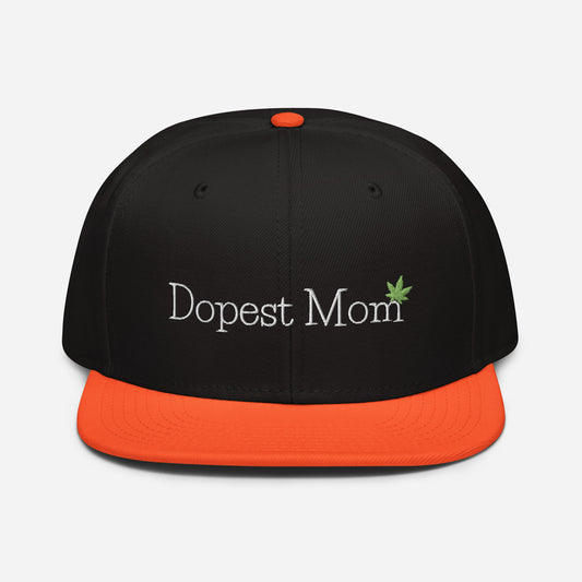 Black and orange Dopest Mom Cannabis snapback hat with the text "dopest mom" and a green leaf emblem embroidered on the front.