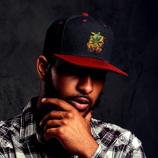 a young man wearing a red and black snapback hat with the warm cannabis paradise logo which consists of weed leaves on a yellow and orange background