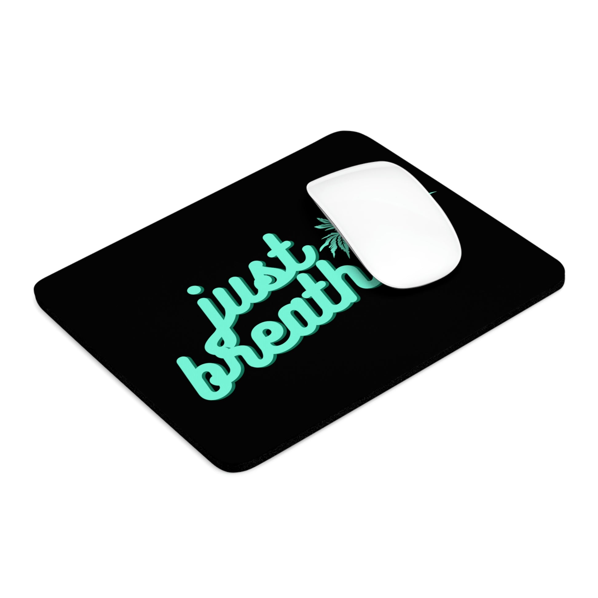 A white computer mouse on a Just Breathe Cannabis black mouse pad with the turquoise text "just breathe.