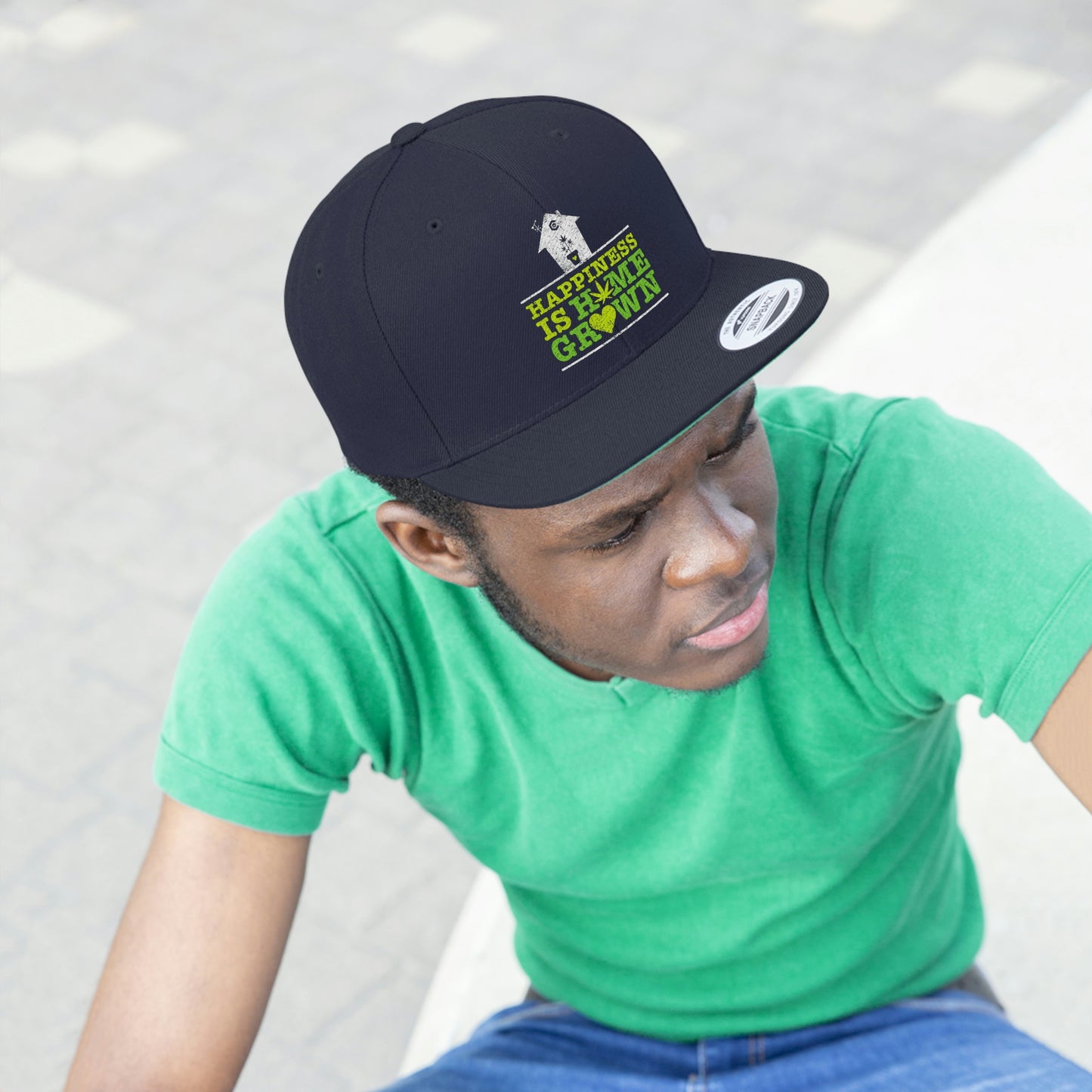 Photo of a young man staring while wearing the navy blue Happiness Is Homegrown Weed Snapback Hat with picture of a white house above the lettering