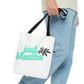 A man is walking in jeans with the Just Breathe Cannabis Tote Bag double clutched in his right hand