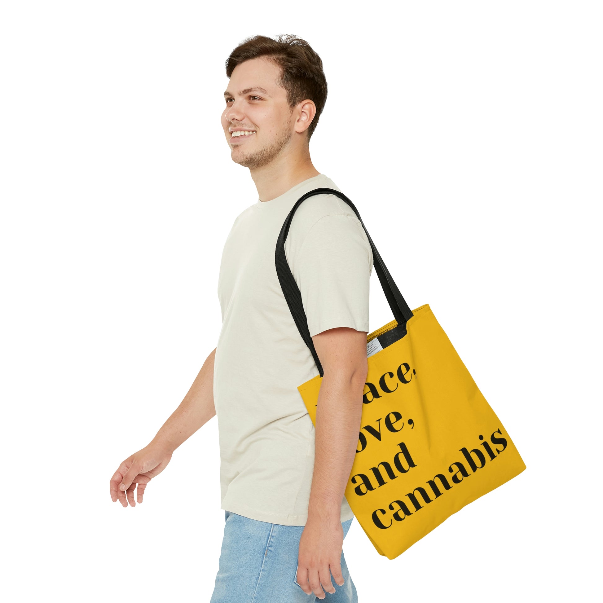 A man shows he is happy with his new Peace, Love and Cannabis Yellow Tote Bag written in nice bold black letters to lay perfectly on the yellow underlay 
