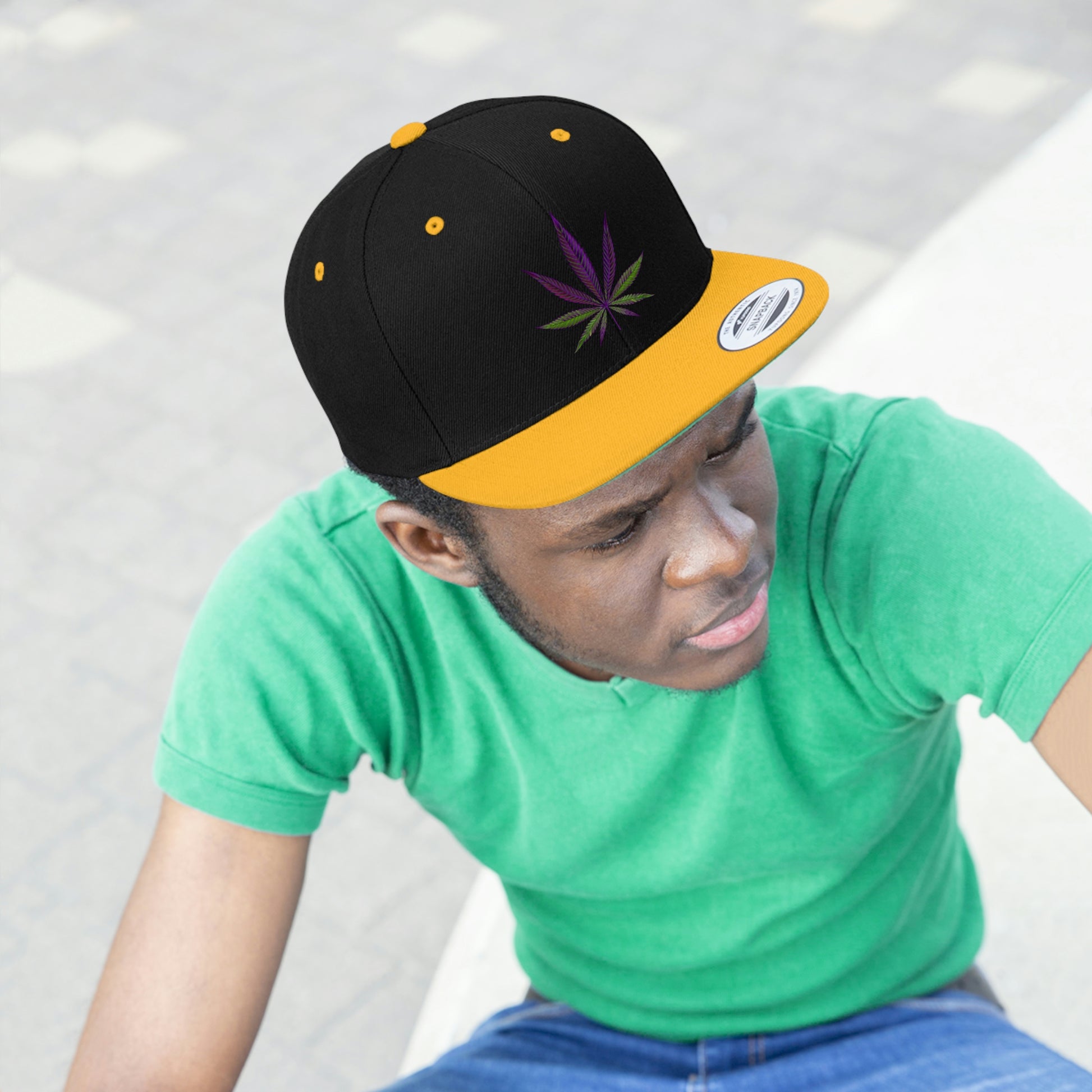 A young man looks on as he wears the Purple Marijuana Leaf Snapback Hat