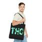 A man is looking over while he is wearing the THC Black Cannabis-Themed Tote Bag