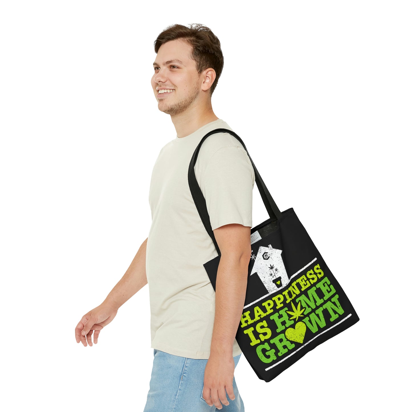 A man cheerfully moves on as he proudly wears the Happiness Is Homegrown Black Marijuana Tote Bag