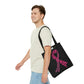 A man is carrying the marijuana Breast Cancer Awareness Black Tote Bag over his shoulder while cheerfully walking