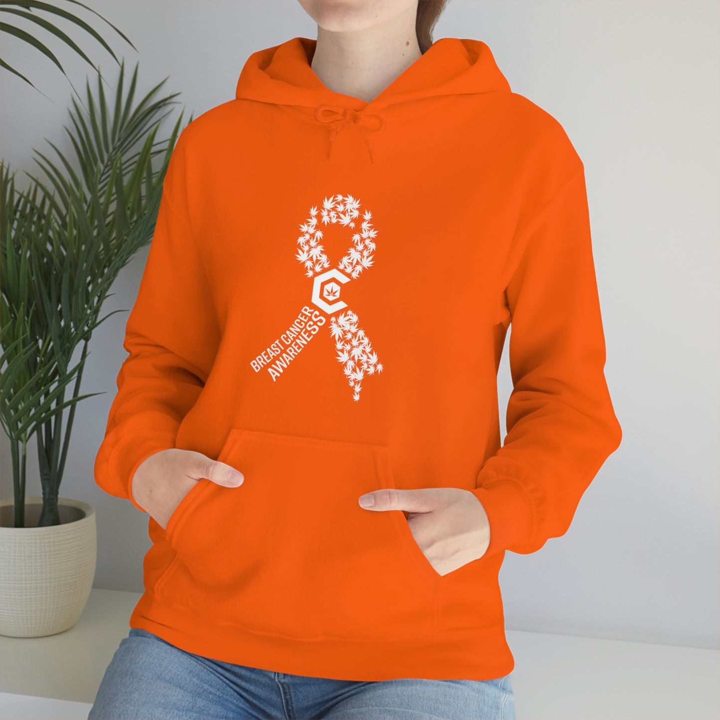 a woman wearing a Breast Cancer Awareness Cannabis Pullover Hoodie with a white ribbon on it.