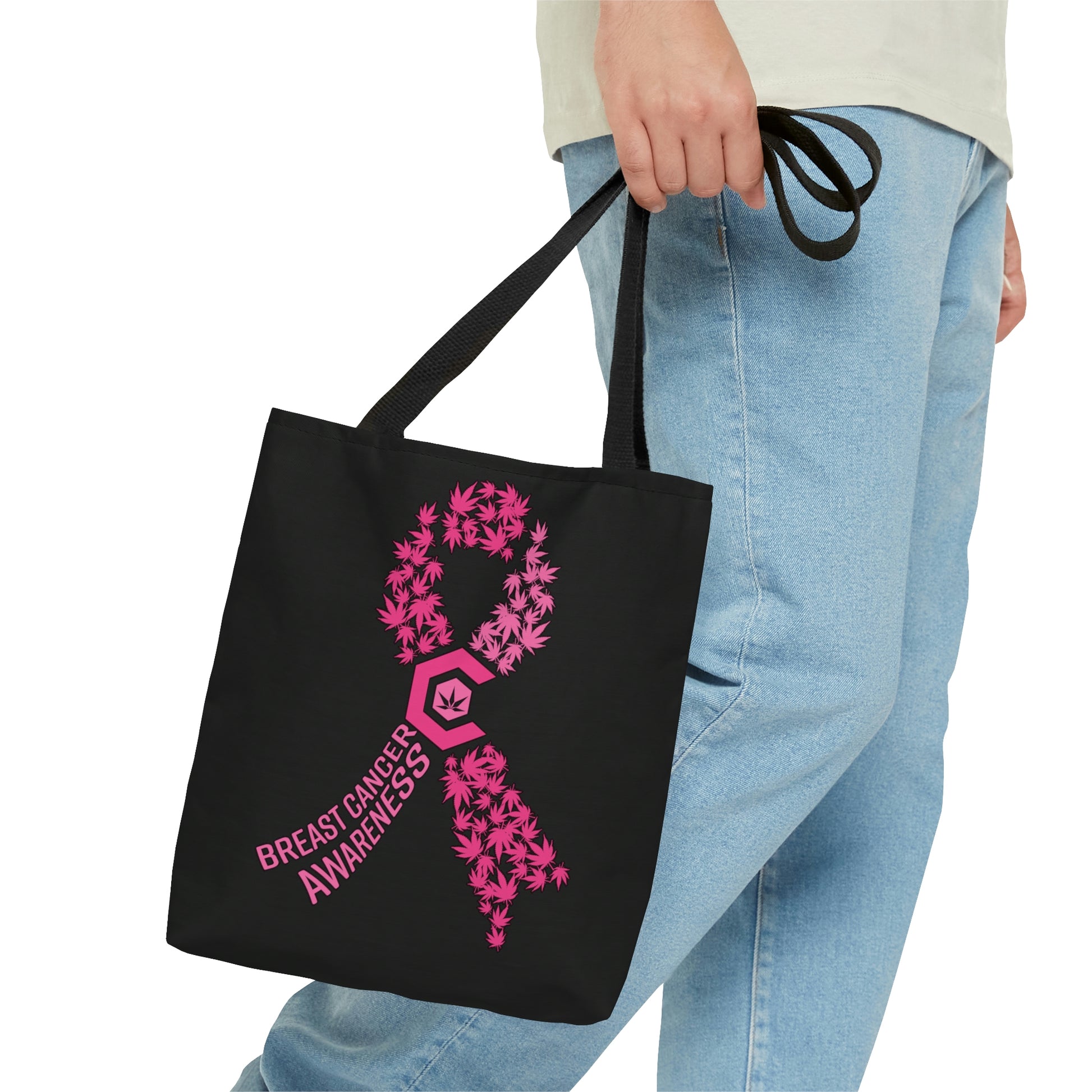 A man clutches the Breast Cancer Awareness Black Tote Bag with pink lettering and pink ribbon design  