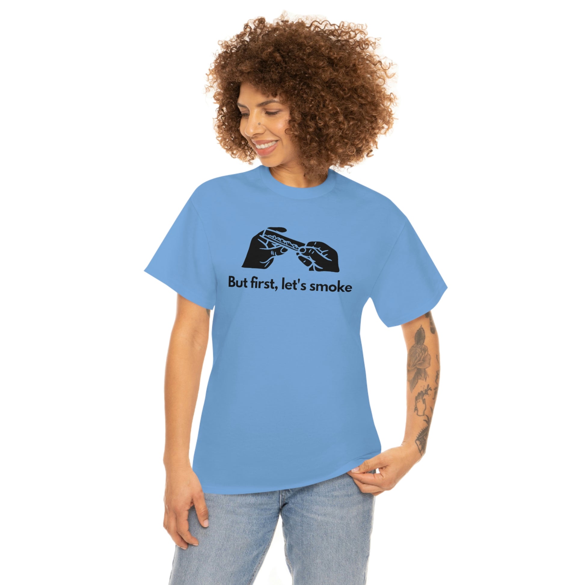 a woman wearing a light blue "But First, Let's Smoke Tee" that says be the change.