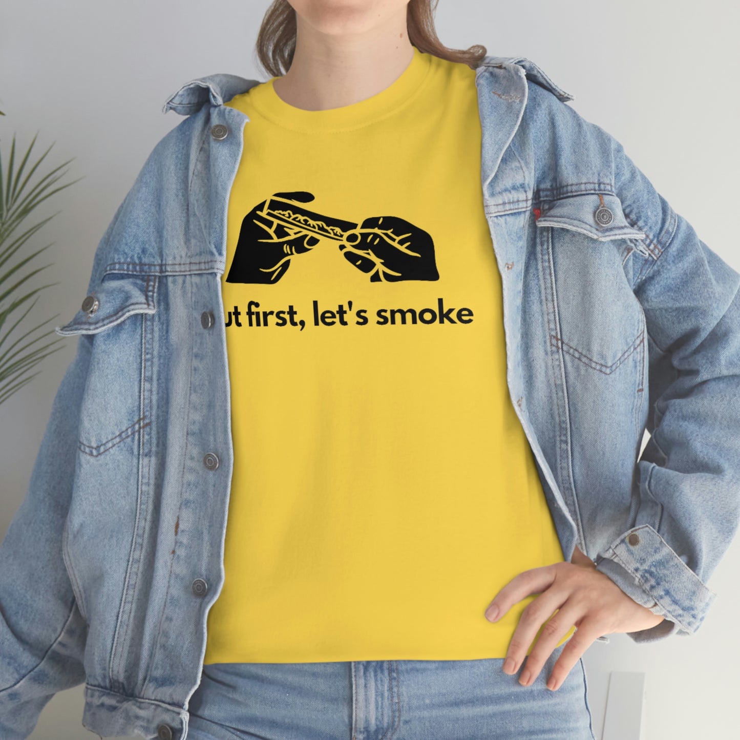 A woman wearing a yellow But First, Let's Smoke Tee.