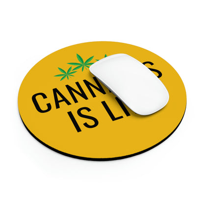 A white computer mouse resting on a Cannabis is Life Yellow Mouse Pad with the text "cannabis is legal" and cannabis leaf icons.