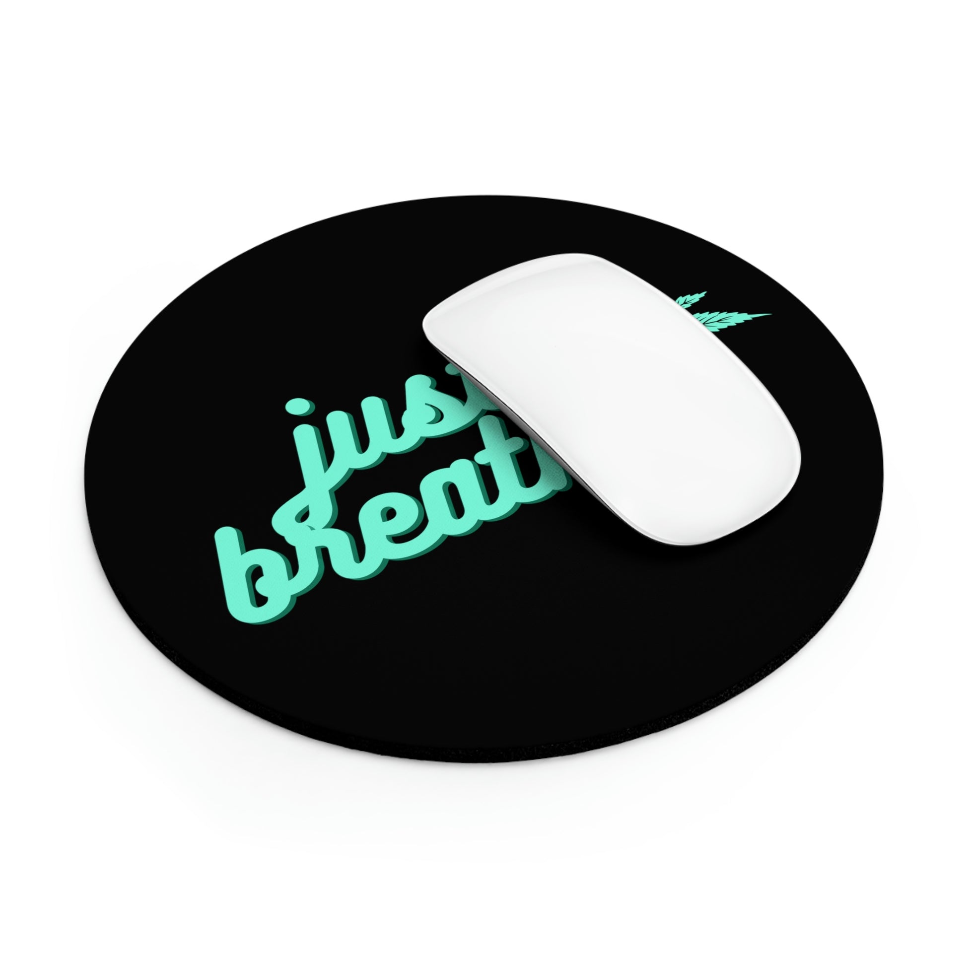 A computer mouse resting on a circular black Just Breathe Cannabis mouse pad with the neon green text "just breathe" and a small graphic design.
