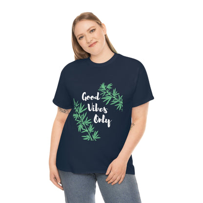 A person wearing the Good Vibes Only Leaf T-Shirt, featuring cannabis leaf graphics on a navy background, stands against a plain white backdrop.