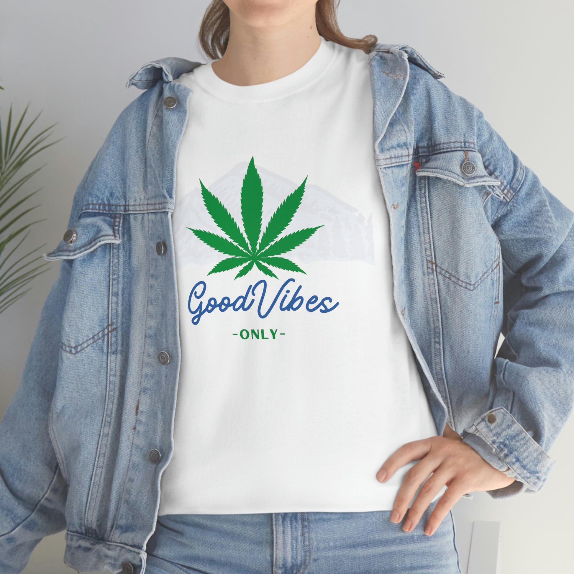 A woman wearing a white t-shirt with the product name "Good Vibes Only Mountain Tee" on it.