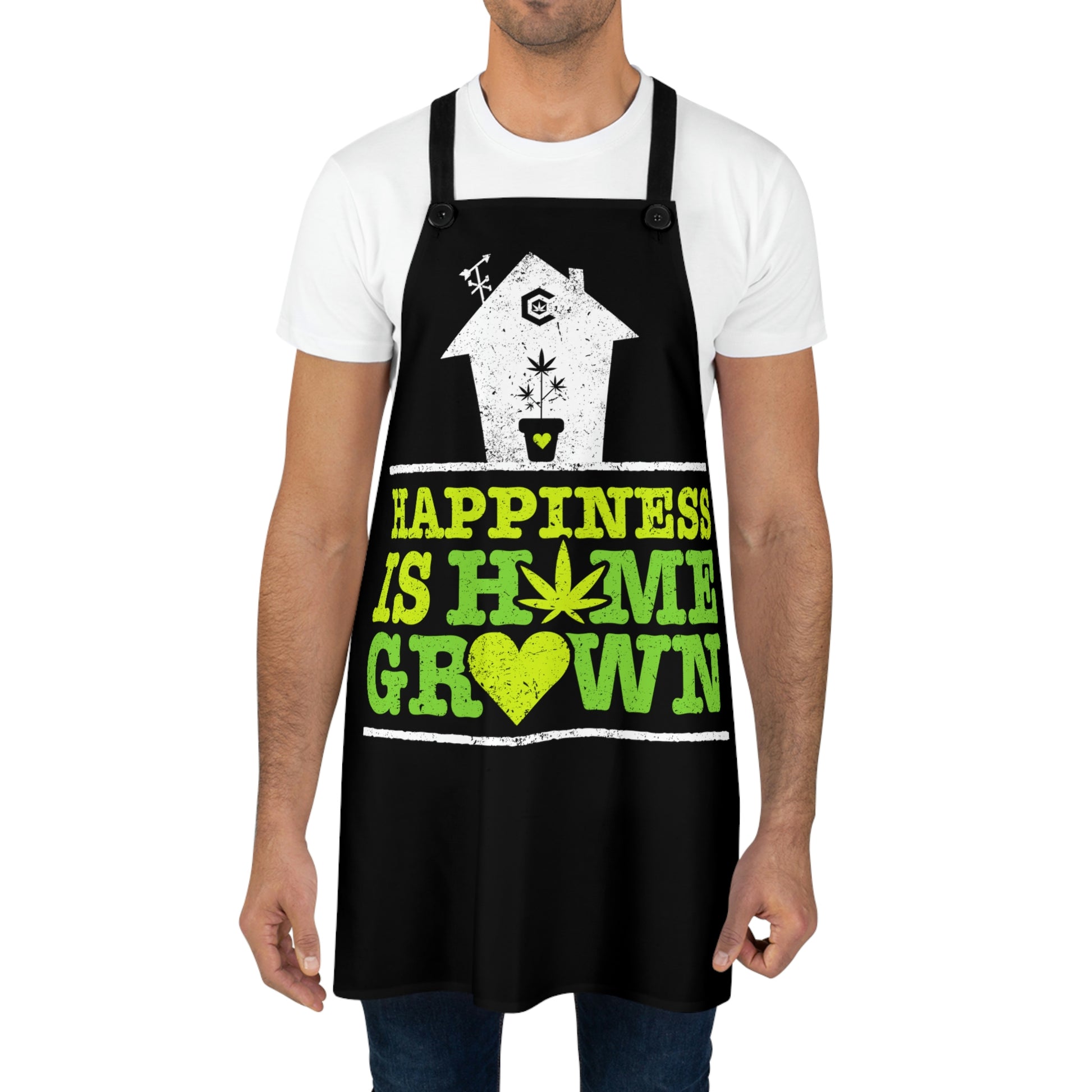 A man wears the Happiness is Homegrown Chef's Apron with a heart and cannabis leaf 